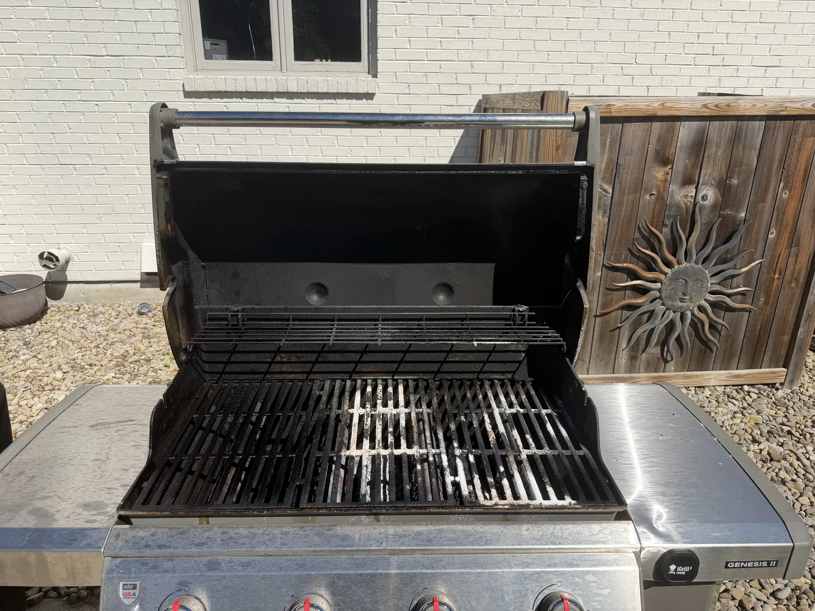 Before: a Weber Genesis II gas grill, lid open — grease-darkened grates and a soot-stained hood interior